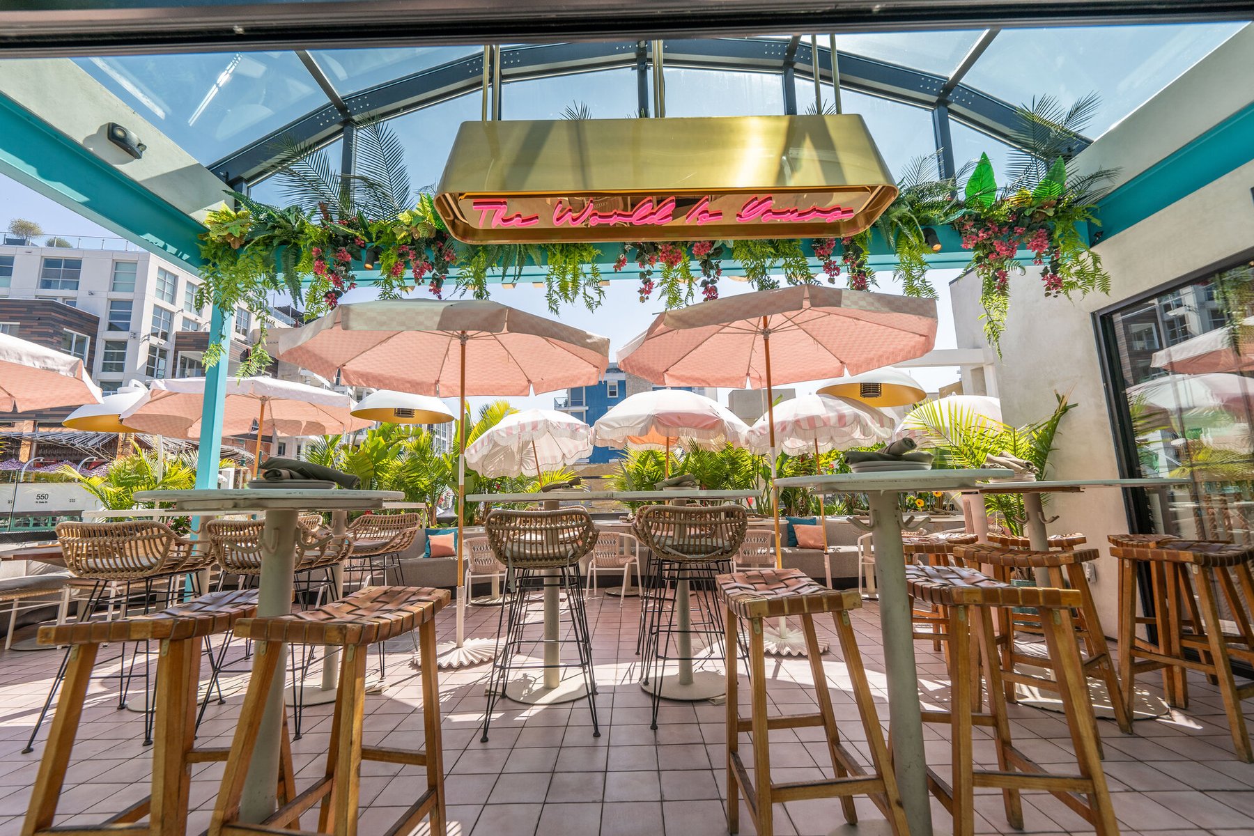 Rooftop patio with pink umbrellas at Coco Maya happy hour, Little Italy San Diego